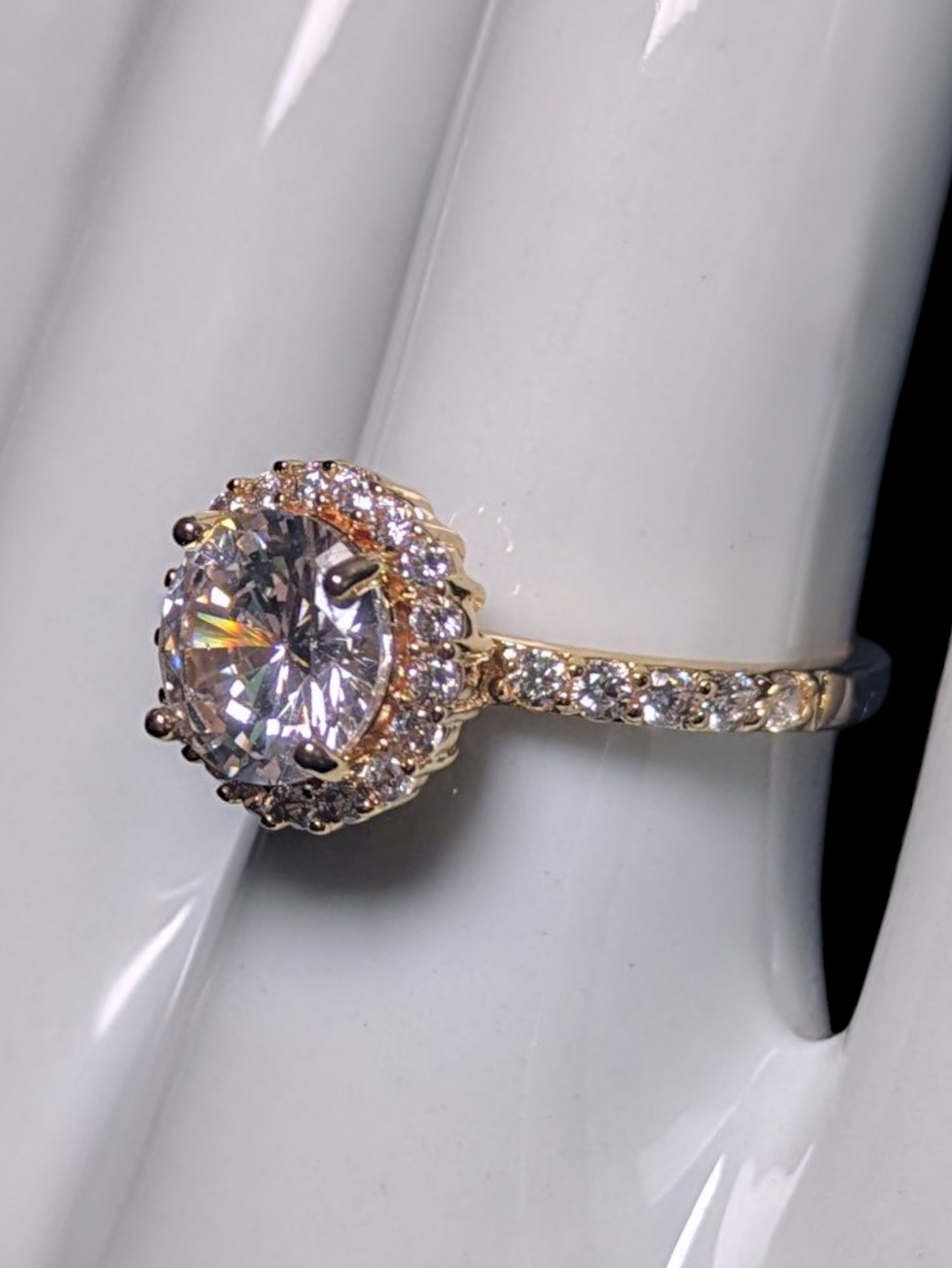 Vintage Inspired Round Cut Simulated Diamond Solitaire with Simulated Diamond Halo and Accented Gold Toned Vacation Ring