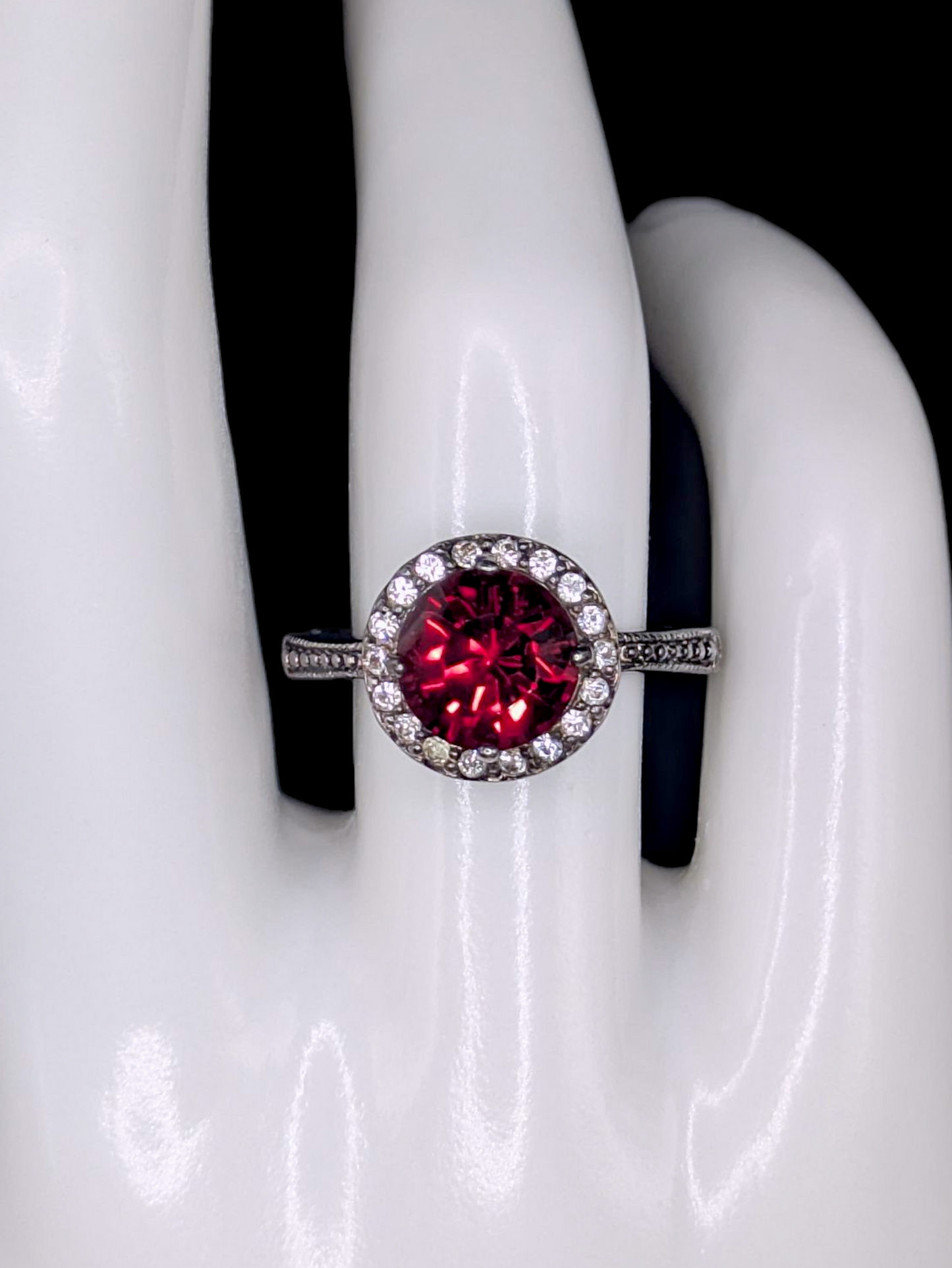 Vintage Inspired Round Single Cut Simulated Ruby Solitaire with Simulated Diamond Halo on Intricate Mount Oxidized Silver Toned Ring
