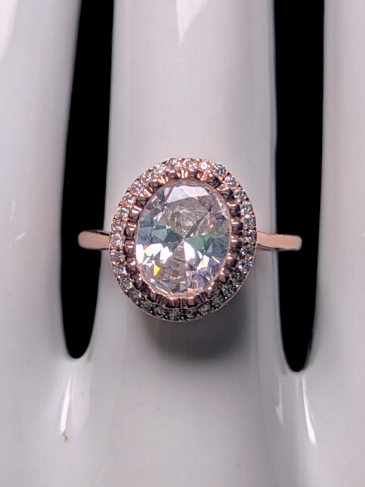 Vintage Inspired Simulated Diamond Solitaire with Simulated Diamond Halo with Asymmetrical Designed Mount Rose Gold Toned Ring