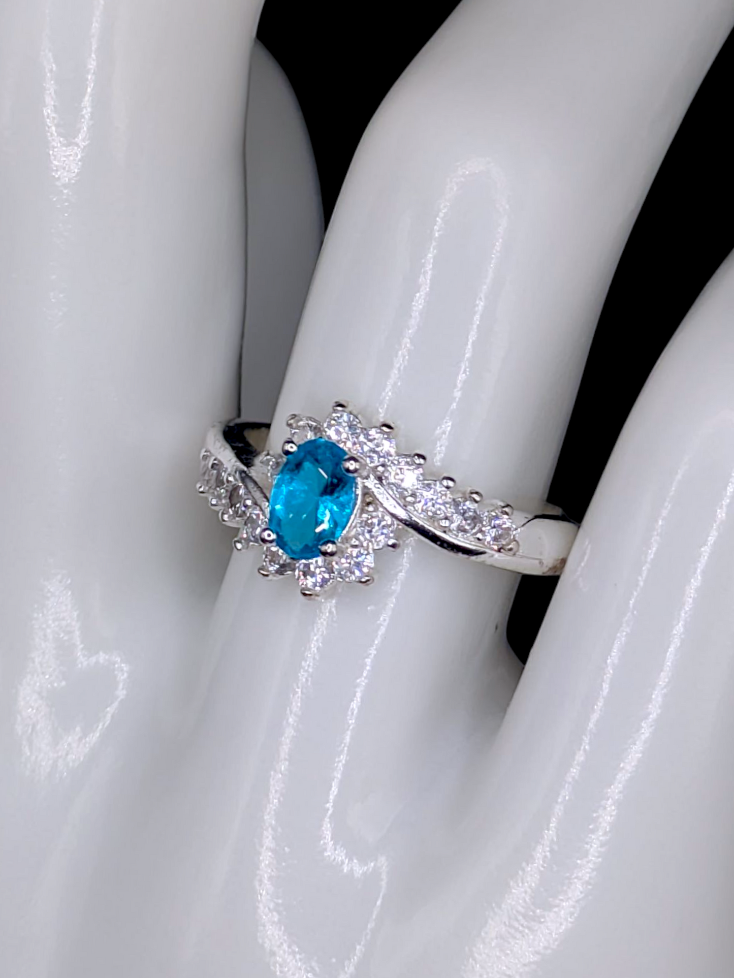 Vintage Inspired Oval Cut Simulated Aquamarine Solitaire with Simulated Diamond Sunburst Crossover Halo Silver Toned Ring