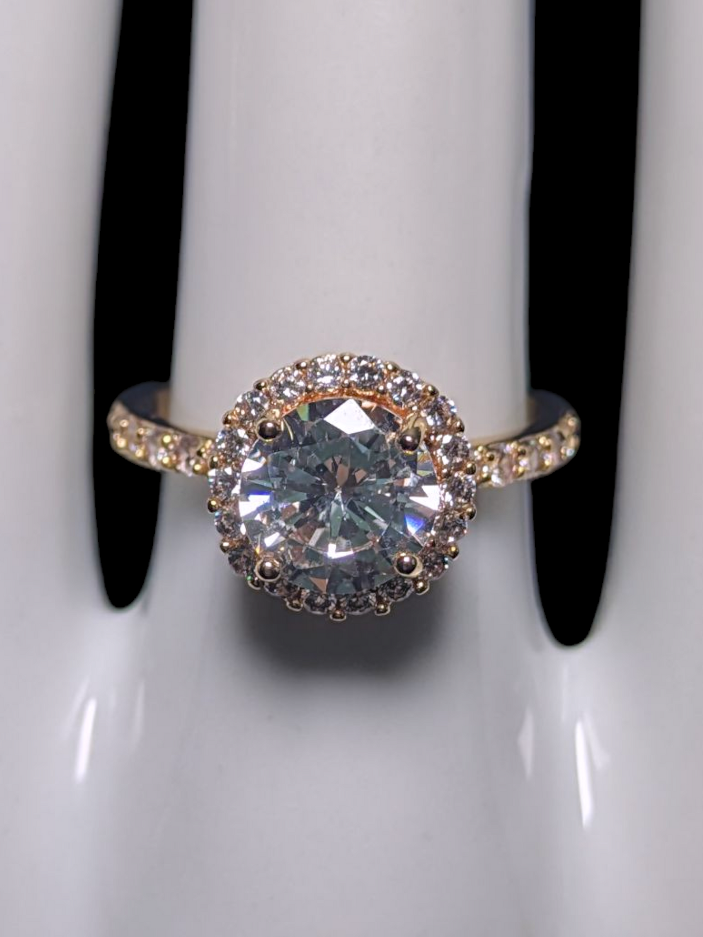 Vintage Inspired Round Cut Simulated Diamond Solitaire with Simulated Diamond Halo and Accented Gold Toned Vacation Ring
