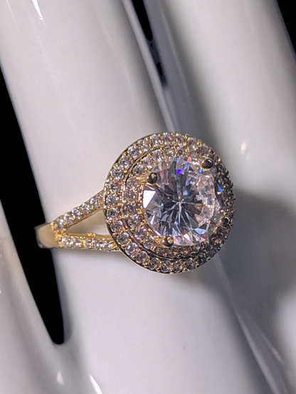 Vintage Inspired Round Cut Simulated Diamond Solitaire with Simulated Diamond Double Halo and Accented Band Gold Toned Vacation Ring