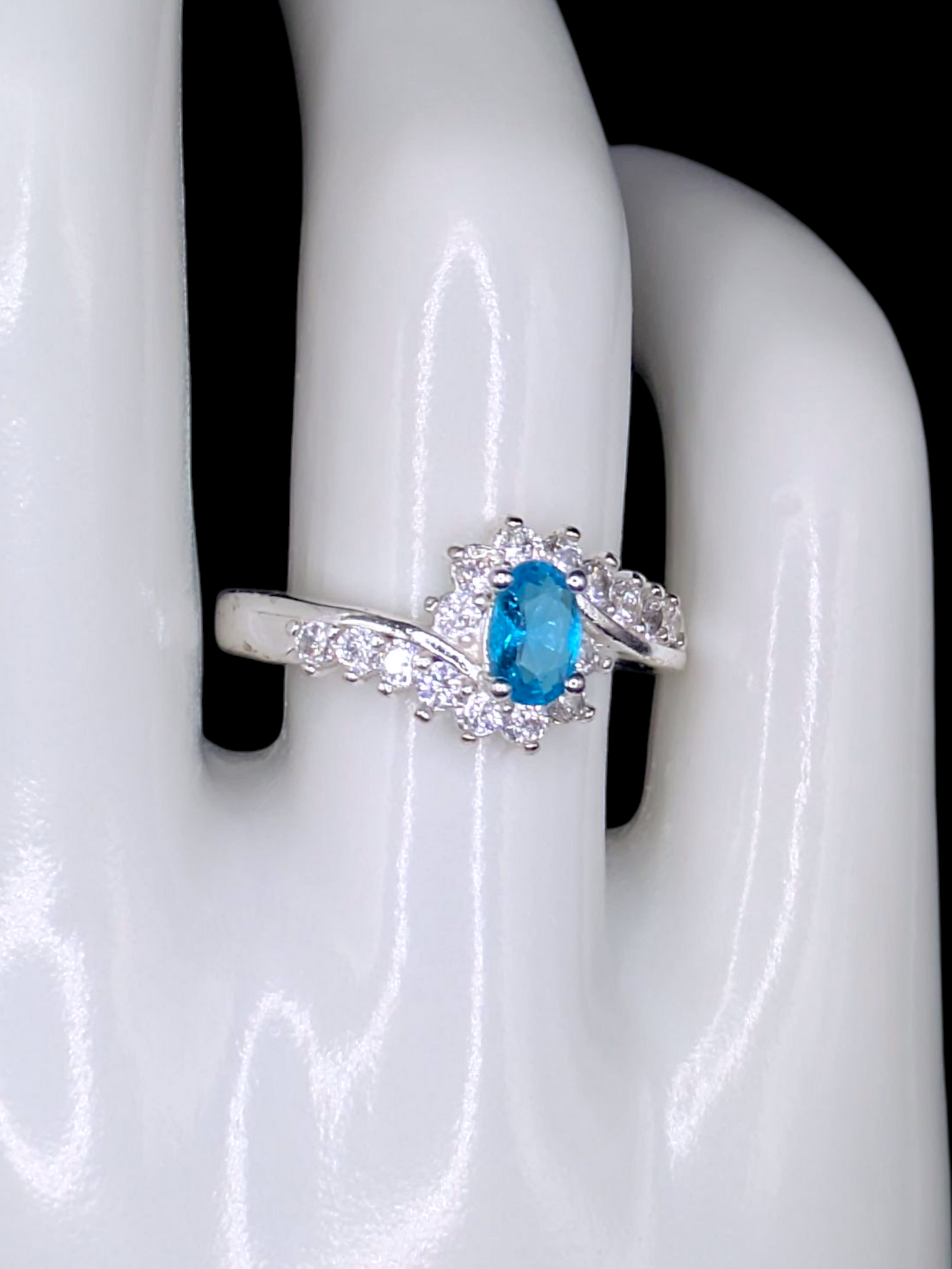 Vintage Inspired Oval Cut Simulated Aquamarine Solitaire with Simulated Diamond Sunburst Crossover Halo Silver Toned Ring