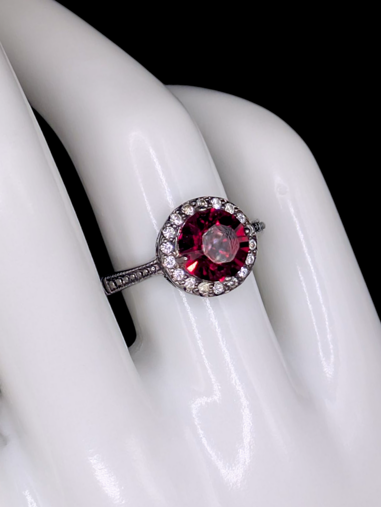 Vintage Inspired Round Single Cut Simulated Ruby Solitaire with Simulated Diamond Halo on Intricate Mount Oxidized Silver Toned Ring