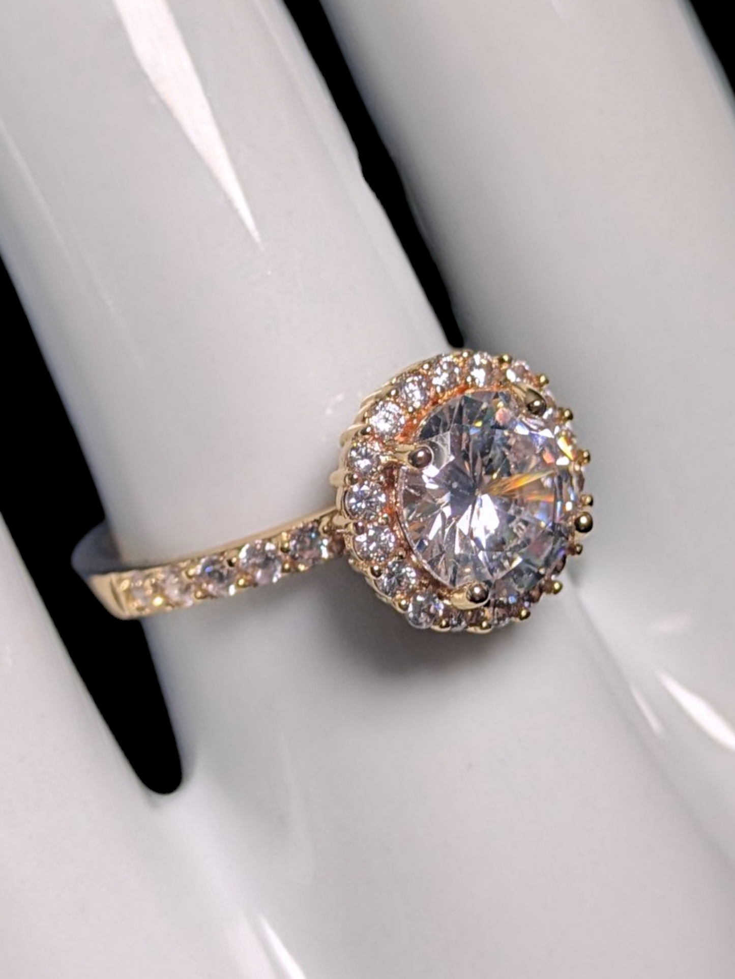 Vintage Inspired Round Cut Simulated Diamond Solitaire with Simulated Diamond Halo and Accented Gold Toned Vacation Ring