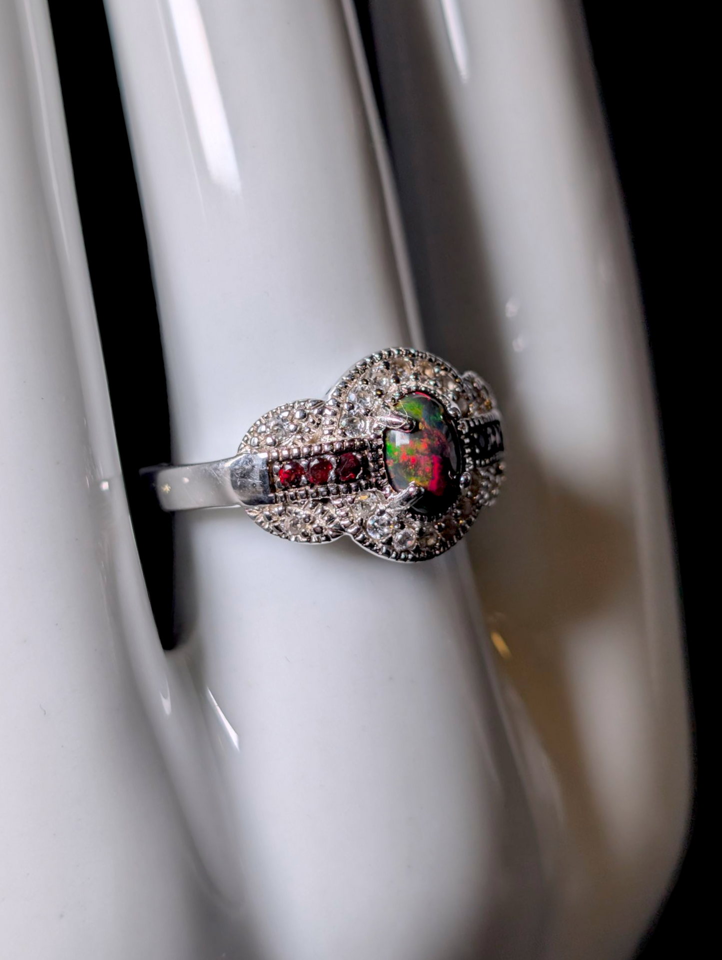 Vintage Cabochon Oval Cut Genuine Black Opal with Garnet Accent Stones and White Topaz Halo Sterling Silver Ring