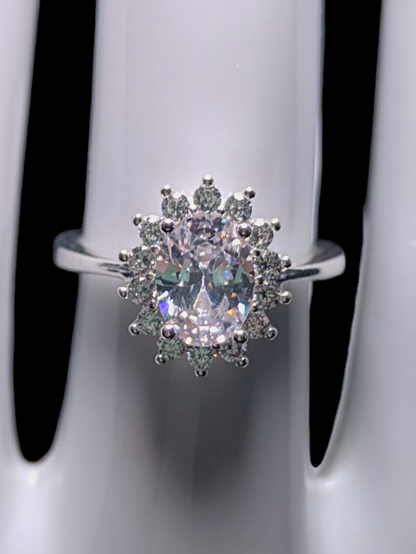 Vintage Inspired Oval Cut Simulated Diamond Solitaire with Simulated Diamond Sunburst Halo Silver Toned Vacation Ring