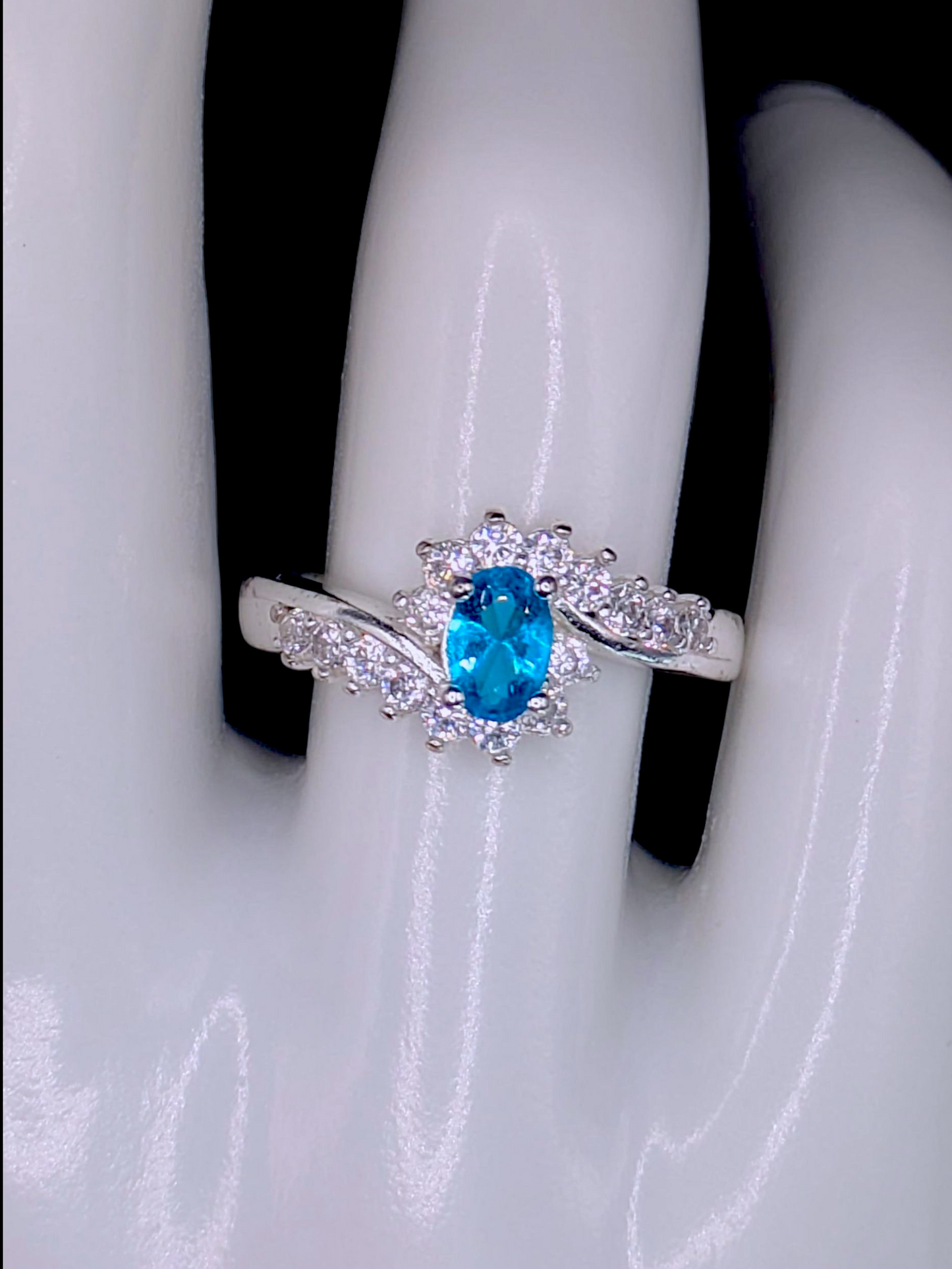 Vintage Inspired Oval Cut Simulated Aquamarine Solitaire with Simulated Diamond Sunburst Crossover Halo Silver Toned Ring