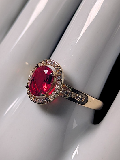 Vintage Inspired Oval Cut Simulated Ruby Solitaire with Simulated Diamond Halo Gold Toned Ring