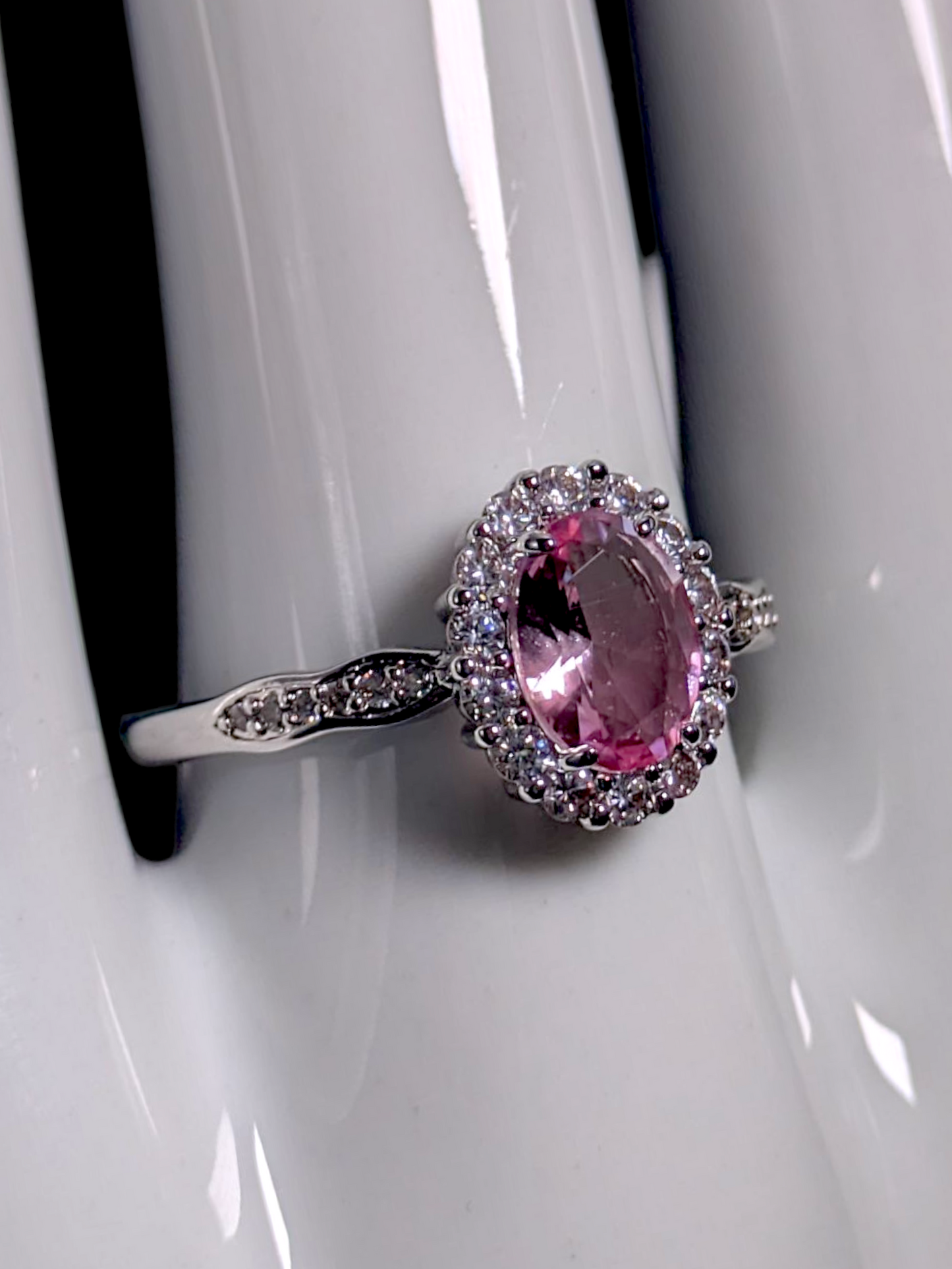 Vintage Inspired Oval Cut Simulated Pink Diamond Solitaire with Simulated Diamond Halo Wavy Silver Toned Ring